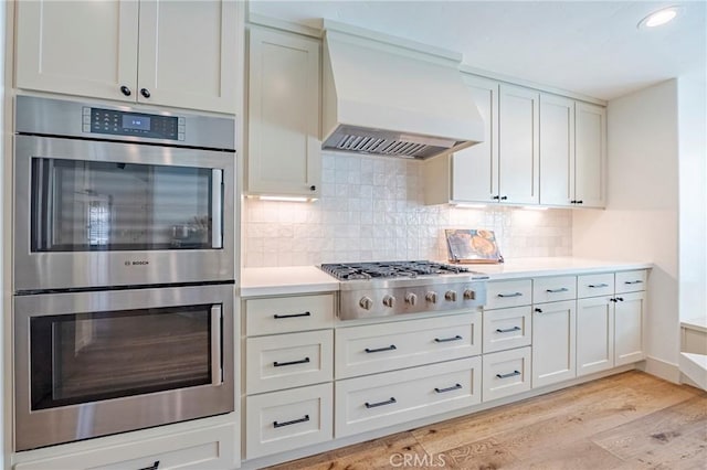 770 Warbler Ct, Merced, CA 95340 - kitchen with appliances with stainless steel finishes, custom range hood, light wood-style flooring, light countertops, and recessed lighting