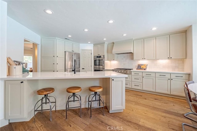 770 Warbler Ct, Merced, CA 95340 - kitchen with premium range hood, appliances with stainless steel finishes, a breakfast bar area, a peninsula, and recessed lighting
