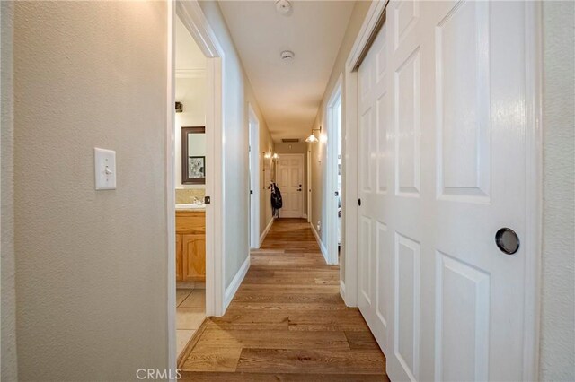 770 Warbler Ct, Merced, CA 95340 - hallway with light wood finished floors and a textured wall