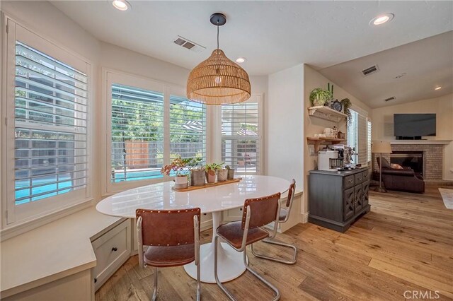 770 Warbler Ct, Merced, CA 95340 - dining area with light wood-style floors, recessed lighting, and a brick fireplace