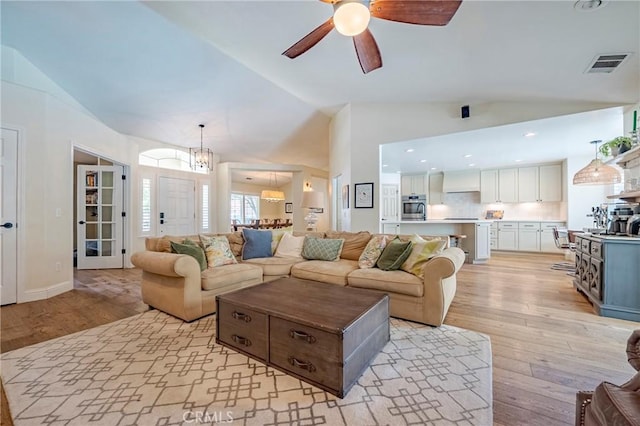 770 Warbler Ct, Merced, CA 95340 - living room with lofted ceiling, a ceiling fan, light wood finished floors, and a chandelier