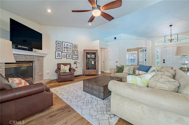 770 Warbler Ct, Merced, CA 95340 - living room featuring ceiling fan, lofted ceiling, a fireplace, wood finished floors, and a chandelier