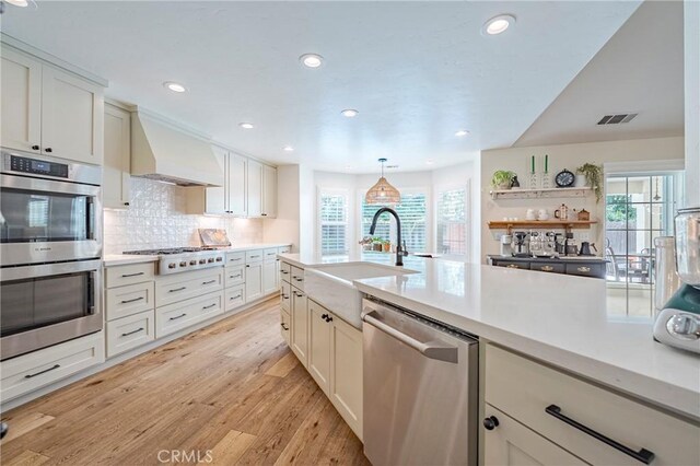 770 Warbler Ct, Merced, CA 95340 - kitchen featuring appliances with stainless steel finishes, plenty of natural light, light countertops, custom exhaust hood, and recessed lighting