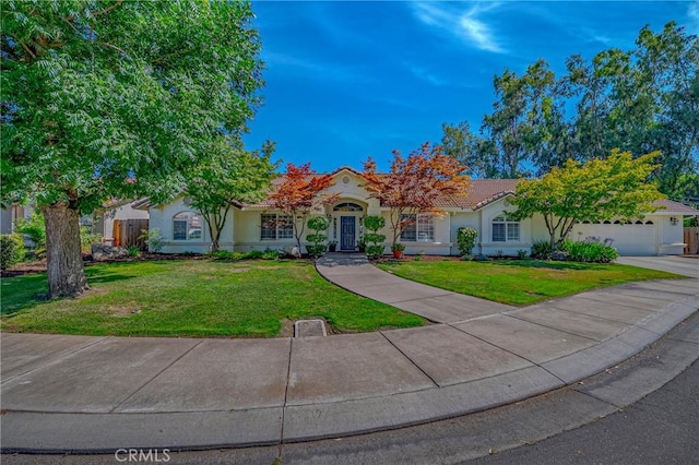 770 Warbler Ct, Merced, CA 95340 - view of property hidden behind natural elements featuring a front lawn, stucco siding, a garage, and a tile roof