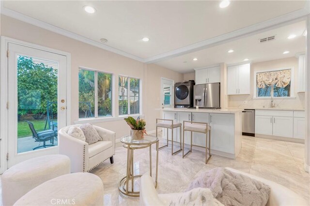 19119 Lemay St, Reseda, CA 91335 - living area with stacked washing machine and dryer, recessed lighting, light marble finish flooring, and ornamental molding
