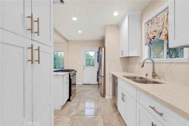 19119 Lemay St, Reseda, CA 91335 - kitchen featuring appliances with stainless steel finishes, white cabinets, light stone countertops, recessed lighting, and light marble finish floors