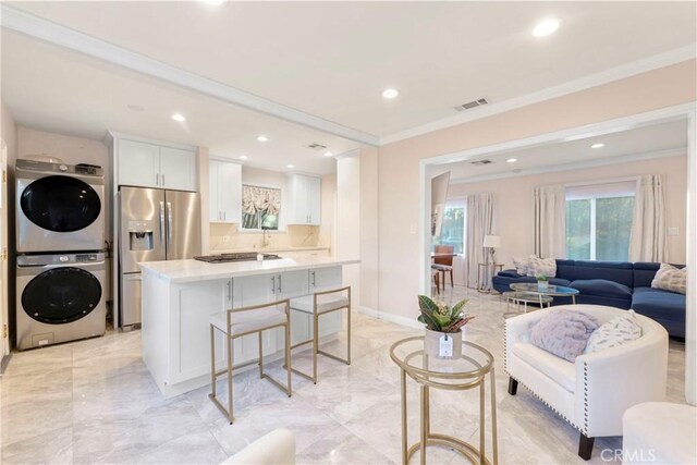 19119 Lemay St, Reseda, CA 91335 - living area with estacked washer and dryer, crown molding, light marble finish flooring, and recessed lighting