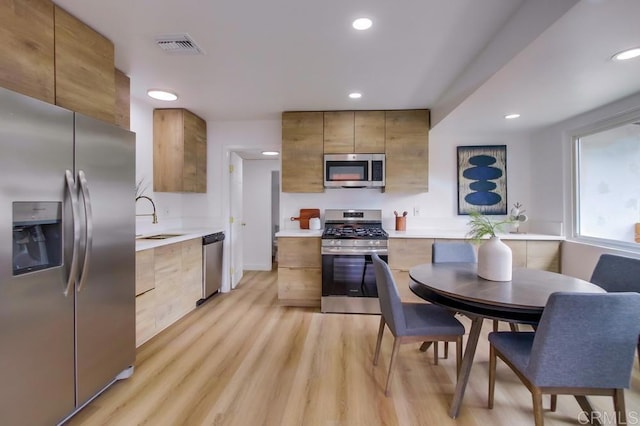 5610 Streamview Dr, San Diego, CA 92105 - kitchen with appliances with stainless steel finishes, modern cabinets, light wood-style floors, light countertops, and recessed lighting