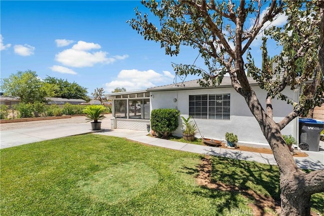 42545 30th St W, Lancaster, CA 93536 - view of front of home with a sunroom, stucco siding, and a front lawn