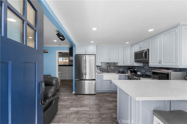 42545 30th St W, Lancaster, CA 93536 - kitchen with appliances with stainless steel finishes, light countertops, white cabinetry, tasteful backsplash, and recessed lighting