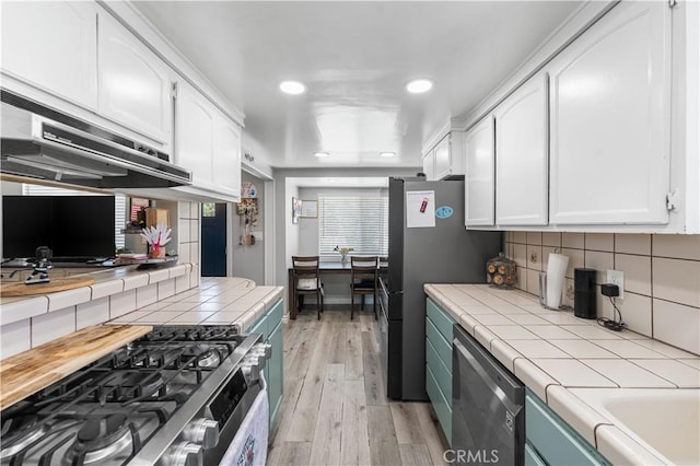 42545 30th St W, Lancaster, CA 93536 - kitchen featuring tile countertops, stainless steel appliances, white cabinetry, recessed lighting, and light wood-style floors