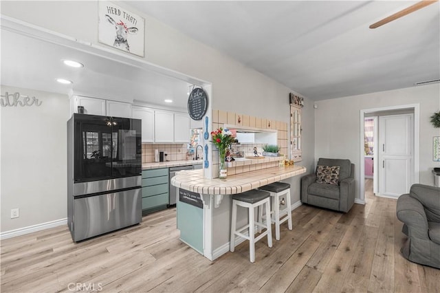 42545 30th St W, Lancaster, CA 93536 - kitchen with smart refrigerator, tile counters, light wood-style floors, tasteful backsplash, and open floor plan