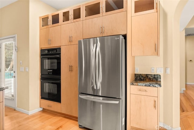 13962 Lindbergh Cir, Chico, CA 95973 - kitchen featuring freestanding refrigerator, light wood-type flooring, arched walkways, light brown cabinets, and glass insert cabinets