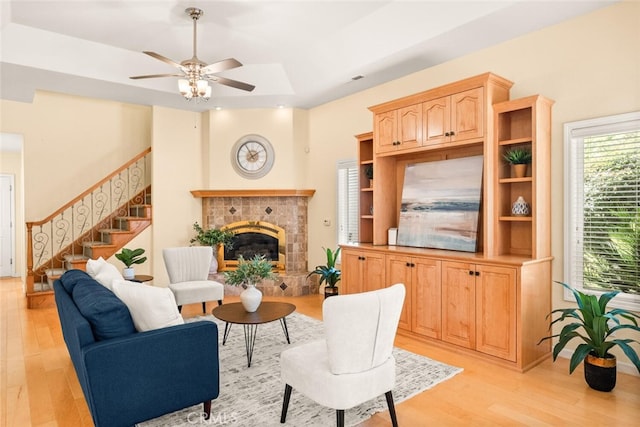 13962 Lindbergh Cir, Chico, CA 95973 - living room featuring a tile fireplace, light wood finished floors, stairway, and a ceiling fan