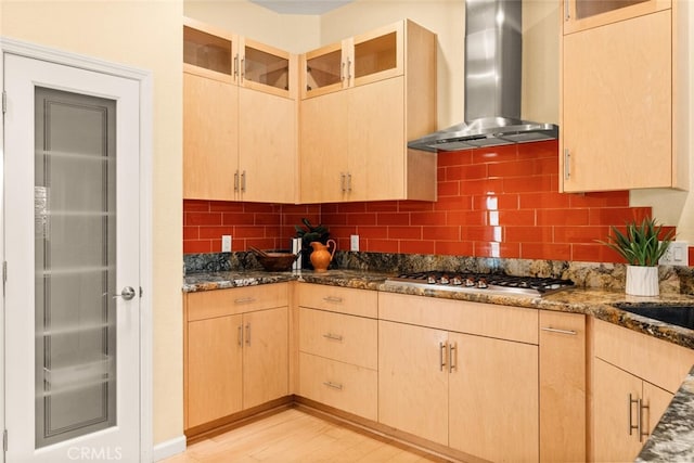 13962 Lindbergh Cir, Chico, CA 95973 - kitchen featuring wall chimney range hood, light brown cabinets, stainless steel gas stovetop, dark stone counters, and decorative backsplash
