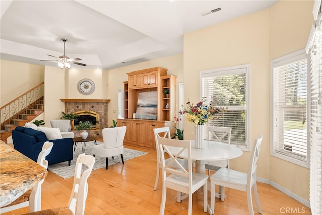 13962 Lindbergh Cir, Chico, CA 95973 - dining area with a brick fireplace, light wood-style flooring, stairs, and a ceiling fan