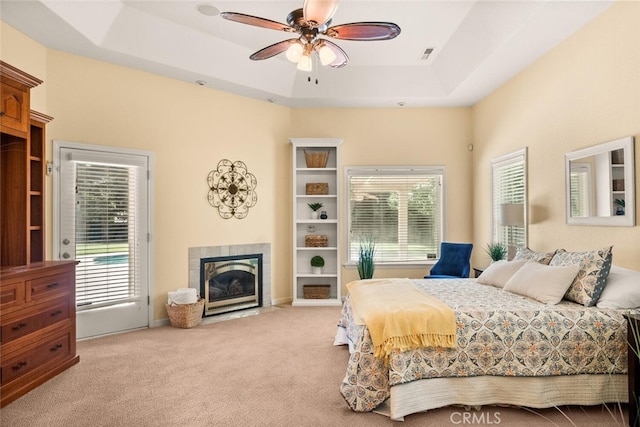 13962 Lindbergh Cir, Chico, CA 95973 - carpeted bedroom with a tiled fireplace, multiple windows, access to exterior, and a tray ceiling