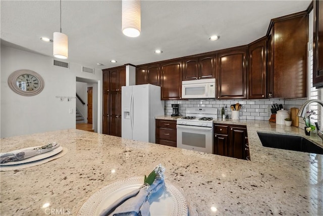 21643 Masterson Ct, Saugus, CA 91350 - kitchen with white appliances, light stone counters, dark brown cabinetry, backsplash, and recessed lighting