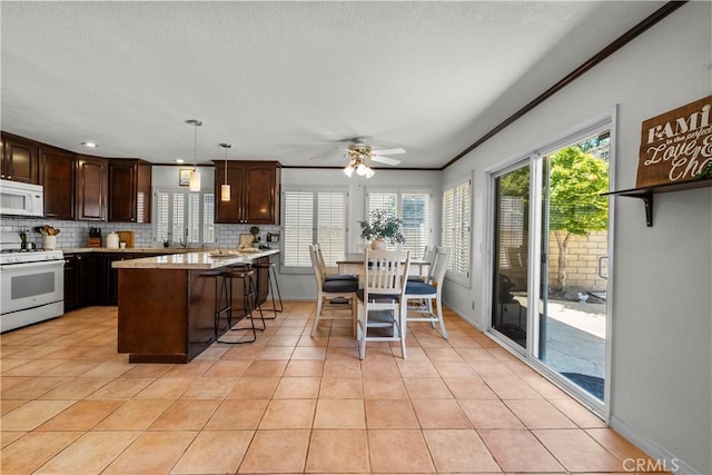 21643 Masterson Ct, Saugus, CA 91350 - kitchen featuring white appliances, backsplash, dark brown cabinetry, light tile patterned floors, and crown molding