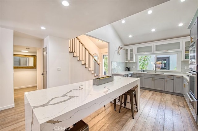 2008 Baja, Newport Beach, CA 92660 - kitchen with gray cabinetry, light wood-style flooring, decorative backsplash, light stone counters, and recessed lighting
