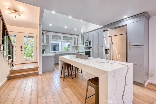 2008 Baja, Newport Beach, CA 92660 - kitchen featuring built in appliances, gray cabinetry, a kitchen breakfast bar, lofted ceiling, and recessed lighting
