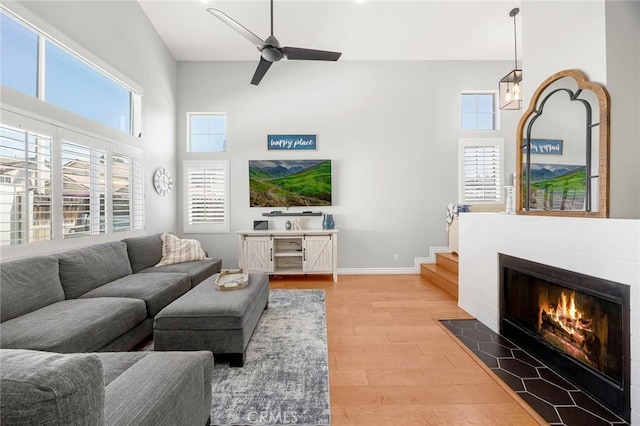 870 Clover Ln, Corona, CA 92878 - living area with light wood-style flooring, ceiling fan, a high ceiling, and a fireplace with flush hearth
