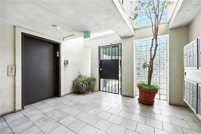 1739 E Broadway Unit 6, Long Beach, CA 90802 - foyer entrance with elevator, light tile patterned flooring, and a textured ceiling