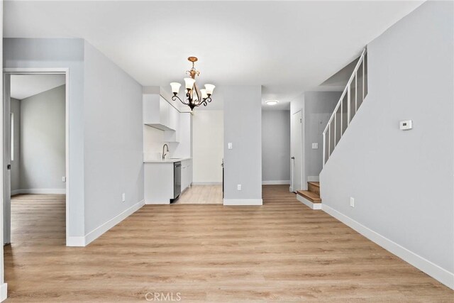 1745 Neil Armstrong St Unit 206, Montebello, CA 90640 - unfurnished living room with a chandelier, stairway, and light wood-style floors