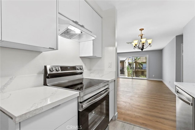 1745 Neil Armstrong St Unit 206, Montebello, CA 90640 - kitchen with stainless steel appliances, light wood finished floors, white cabinetry, a chandelier, and hanging light fixtures