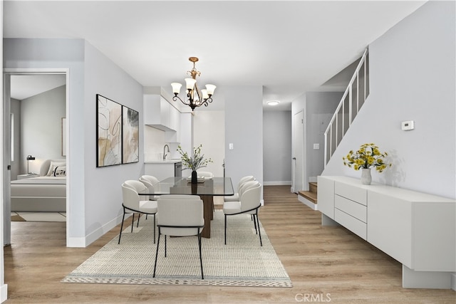 1745 Neil Armstrong St Unit 206, Montebello, CA 90640 - dining room featuring a chandelier, stairs, and light wood-style flooring