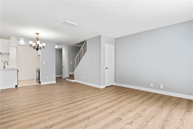 1745 Neil Armstrong St Unit 206, Montebello, CA 90640 - unfurnished living room featuring stairs, light wood-style flooring, and a chandelier