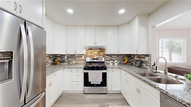 8007 New Salem St, San Diego, CA 92126 - kitchen featuring stainless steel appliances, under cabinet range hood, light wood finished floors, white cabinetry, and decorative backsplash