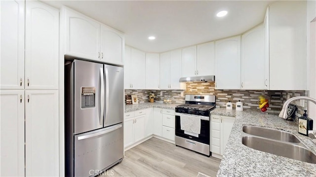 8007 New Salem St, San Diego, CA 92126 - kitchen featuring appliances with stainless steel finishes, under cabinet range hood, light wood-style floors, decorative backsplash, and white cabinets