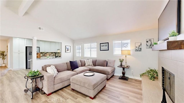 8007 New Salem St, San Diego, CA 92126 - living room featuring light wood-style flooring, a tiled fireplace, beam ceiling, and high vaulted ceiling