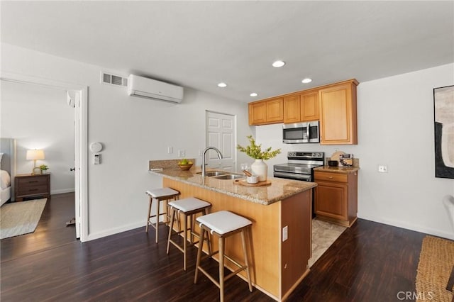 21981 Rimhurst Dr Unit 158, Lake Forest, CA 92630 - kitchen featuring stainless steel appliances, a wall mounted AC, a kitchen bar, recessed lighting, and dark wood-style flooring