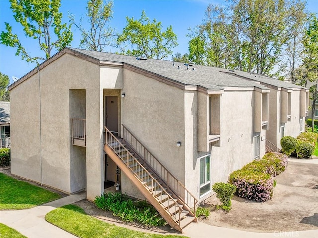 17068 Colima Rd Unit 274, Hacienda Heights, CA 91745 - view of side of property featuring stairway, stucco siding, and roof with shingles