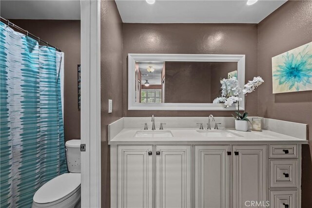 23957 Arroyo Park Dr Unit 146, Valencia, CA 91355 - full bathroom featuring a textured wall, double vanity, and a shower with curtain