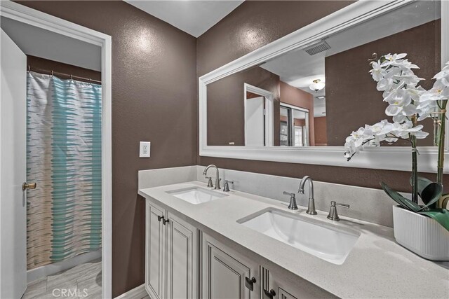 23957 Arroyo Park Dr Unit 146, Valencia, CA 91355 - bathroom featuring a textured wall, double vanity, and a shower with shower curtain