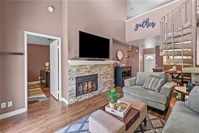 23957 Arroyo Park Dr Unit 146, Valencia, CA 91355 - living room with a high ceiling, stairs, wood finished floors, and a stone fireplace