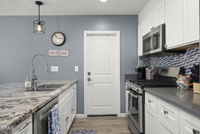3151 W Hemlock St, Oxnard, CA 93035 - kitchen with stainless steel appliances, light wood finished floors, white cabinets, and backsplash