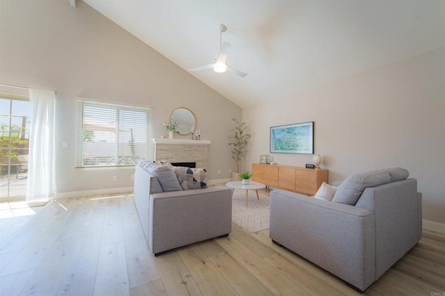 7083 Deerhurst Ct, San Diego, CA 92139 - living room with ceiling fan, a stone fireplace, light wood-type flooring, and high vaulted ceiling