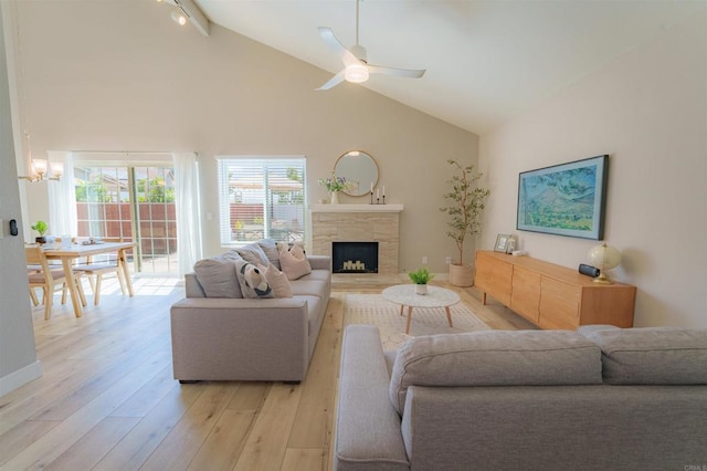 7083 Deerhurst Ct, San Diego, CA 92139 - living area with high vaulted ceiling, light wood-type flooring, a chandelier, a stone fireplace, and a ceiling fan