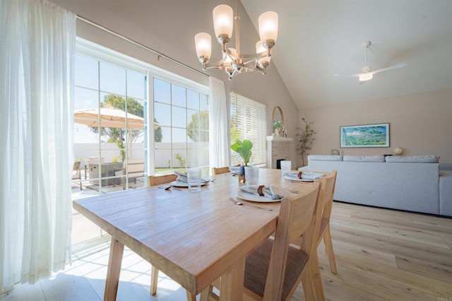 7083 Deerhurst Ct, San Diego, CA 92139 - dining room with a fireplace, light wood-type flooring, ceiling fan, a chandelier, and high vaulted ceiling