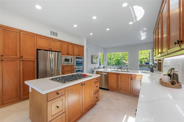 14 Pavona, Newport Coast, CA 92657 - kitchen featuring appliances with stainless steel finishes, recessed lighting, brown cabinets, a center island, and light stone counters