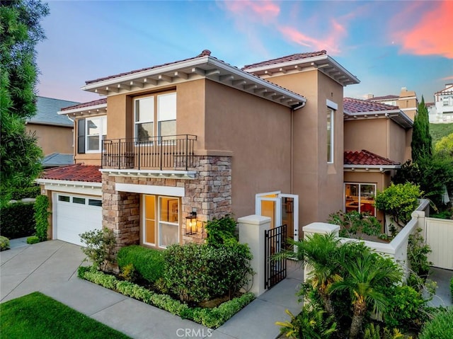 14 Pavona, Newport Coast, CA 92657 - mediterranean / spanish-style home with a balcony, driveway, stone siding, a tile roof, and stucco siding