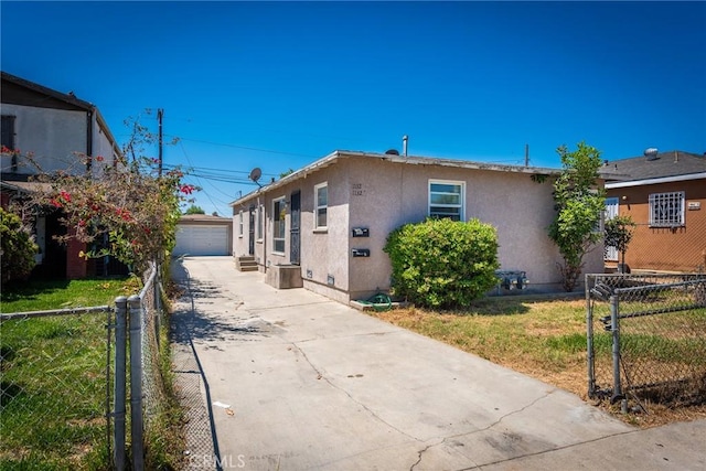 1132 E 65th St, Los Angeles, CA 90001 - view of home's exterior with stucco siding, concrete driveway, an outbuilding, and a garage