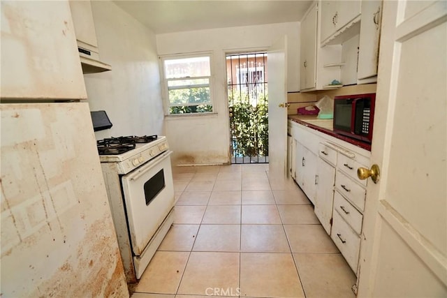 1132 E 65th St, Los Angeles, CA 90001 - kitchen with white appliances, under cabinet range hood, light tile patterned floors, white cabinets, and open shelves