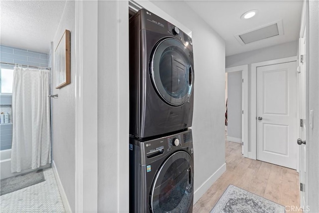 330 Glenshaw Dr, La Puente, CA 91744 - washroom with stacked washer and clothes dryer, attic access, and light wood finished floors