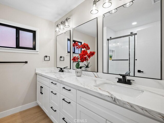 971 N Clifford Ave, Rialto, CA 92376 - bathroom featuring double vanity, wood finished floors, and a shower stall