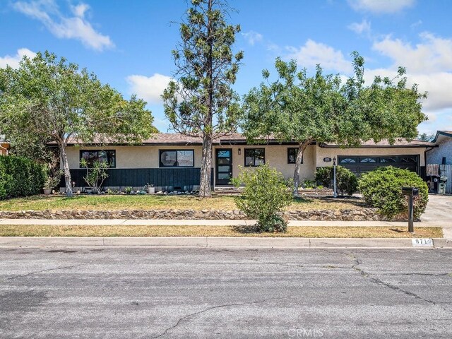 971 N Clifford Ave, Rialto, CA 92376 - ranch-style house with stucco siding, a garage, and concrete driveway